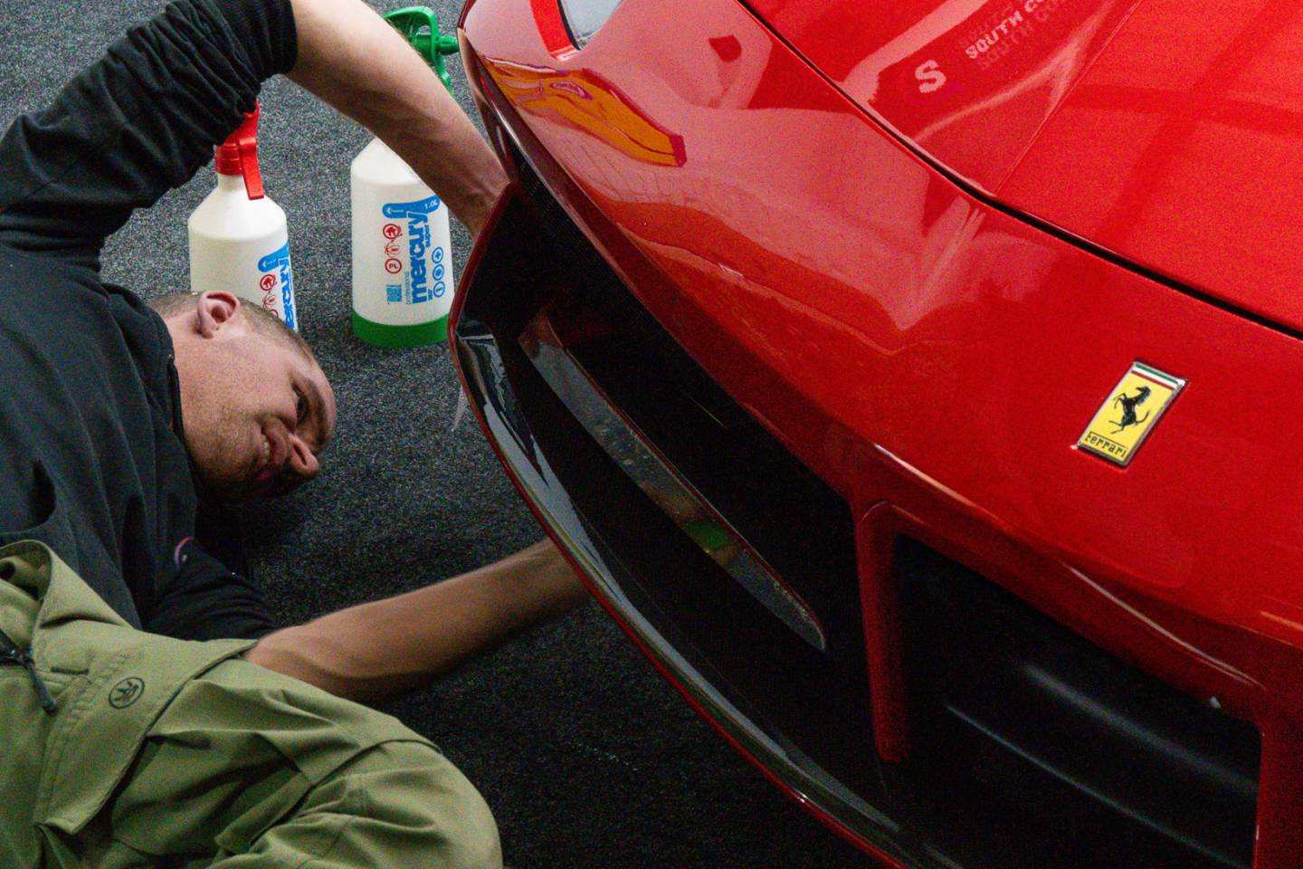 Installer finishing film around a red Ferrari body panel