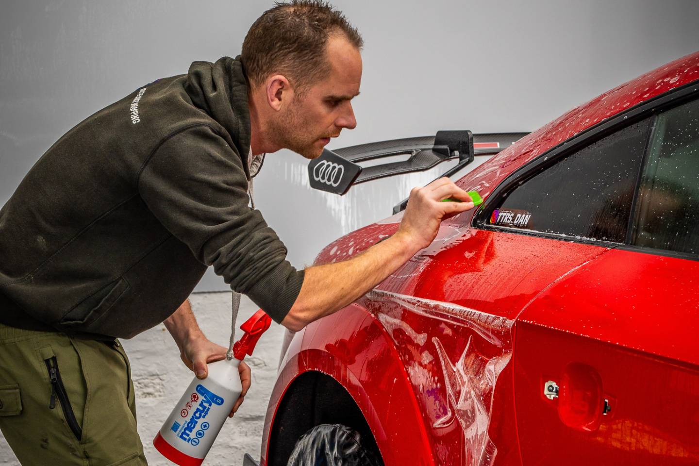 Installer working around a red Ferrari windscreen pillar