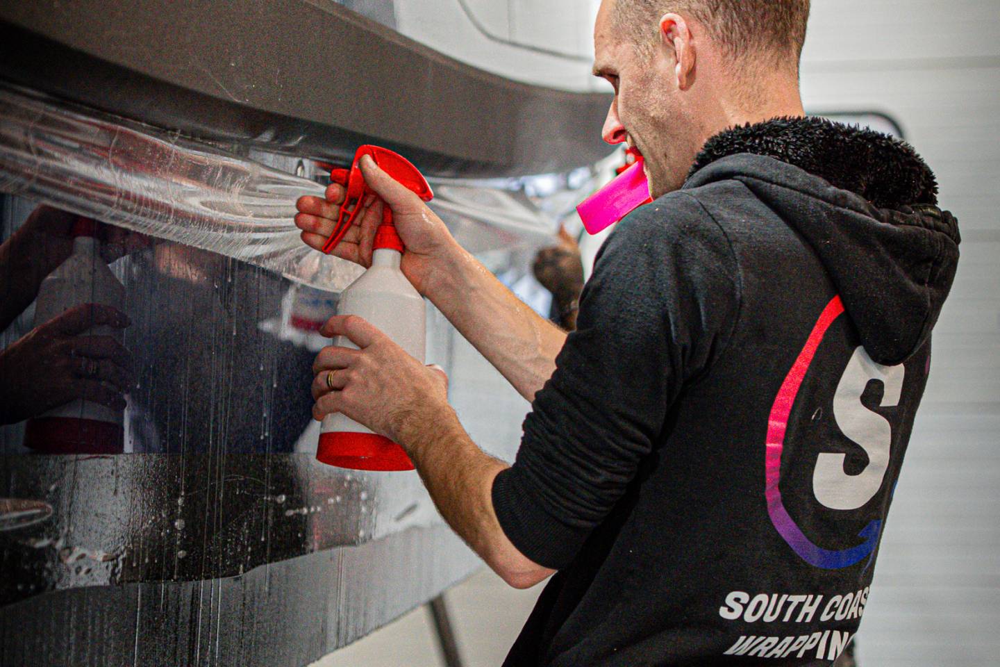 Installer spraying solution onto protective film