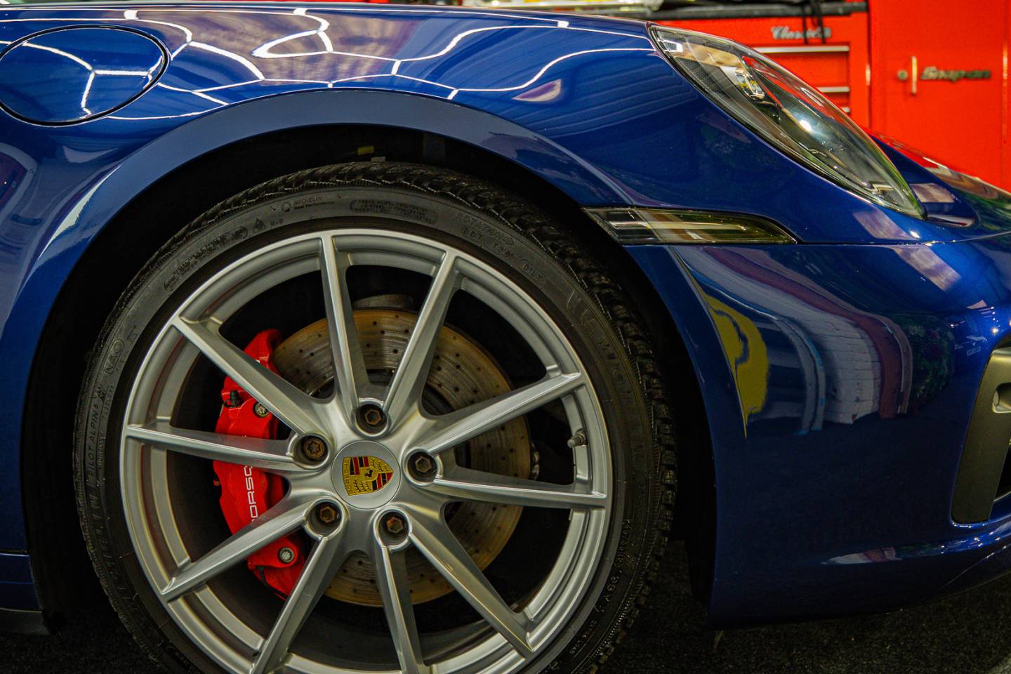Front wheel and blue bodywork on a Porsche