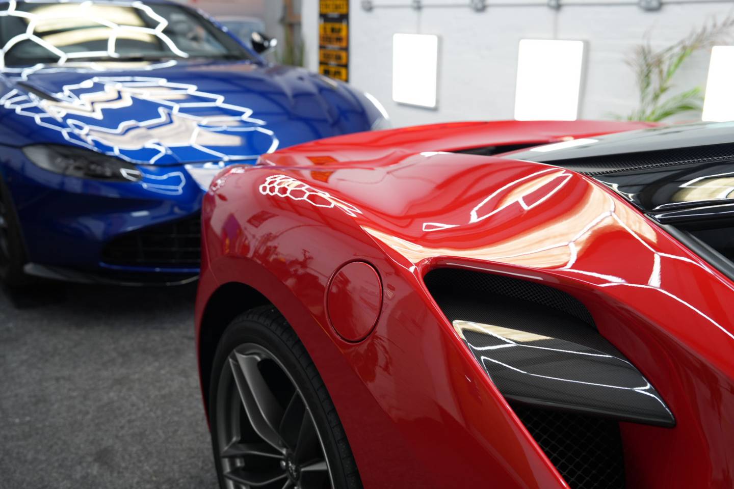 Red and blue sports cars in the workshop