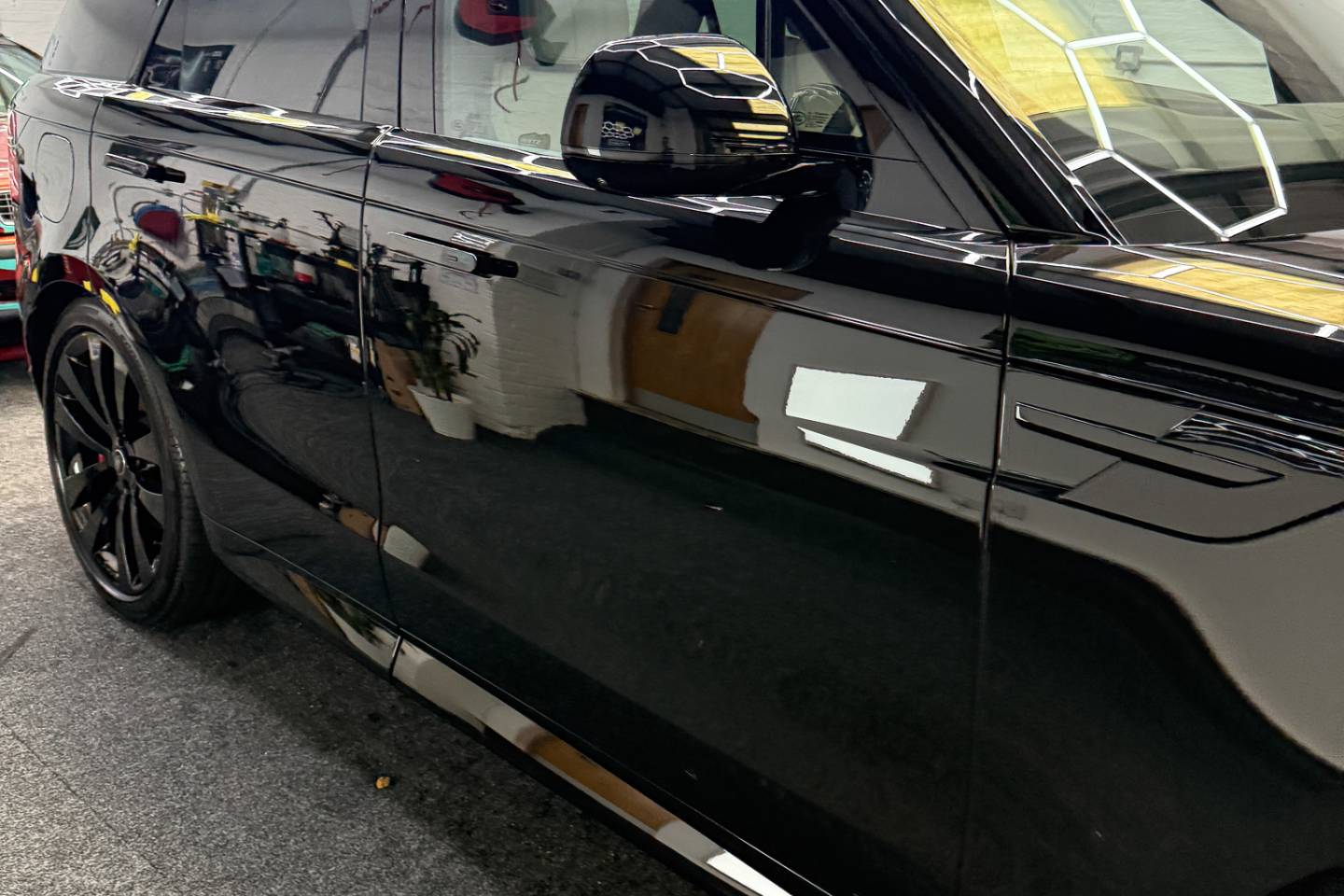 Side view of a black Range Rover in the workshop
