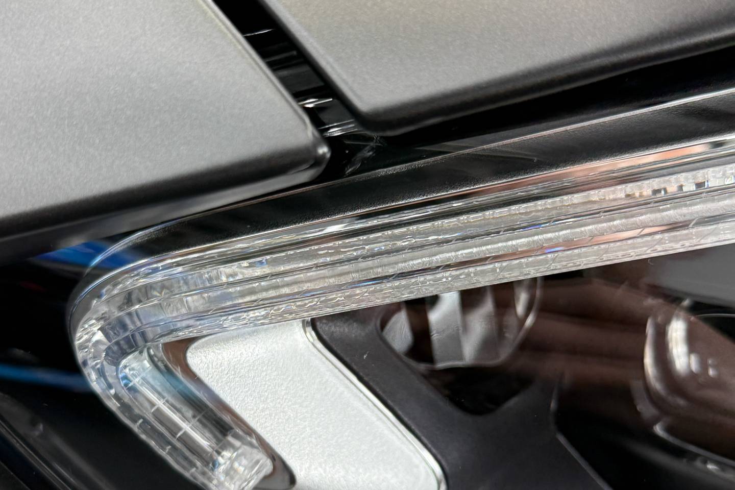 Paint protection film edge beside a headlamp and bonnet