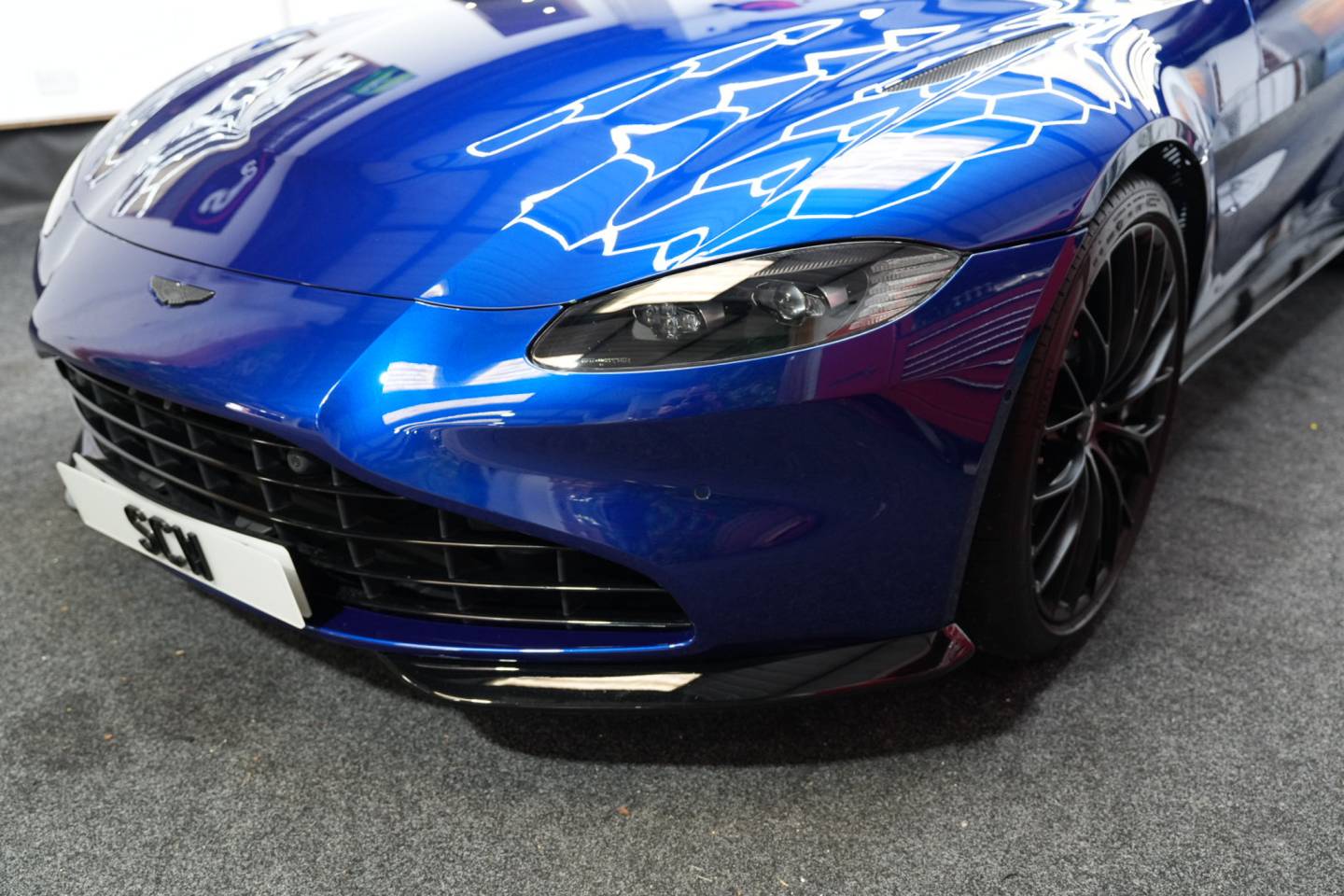 Blue sports car headlamp and front wing detail