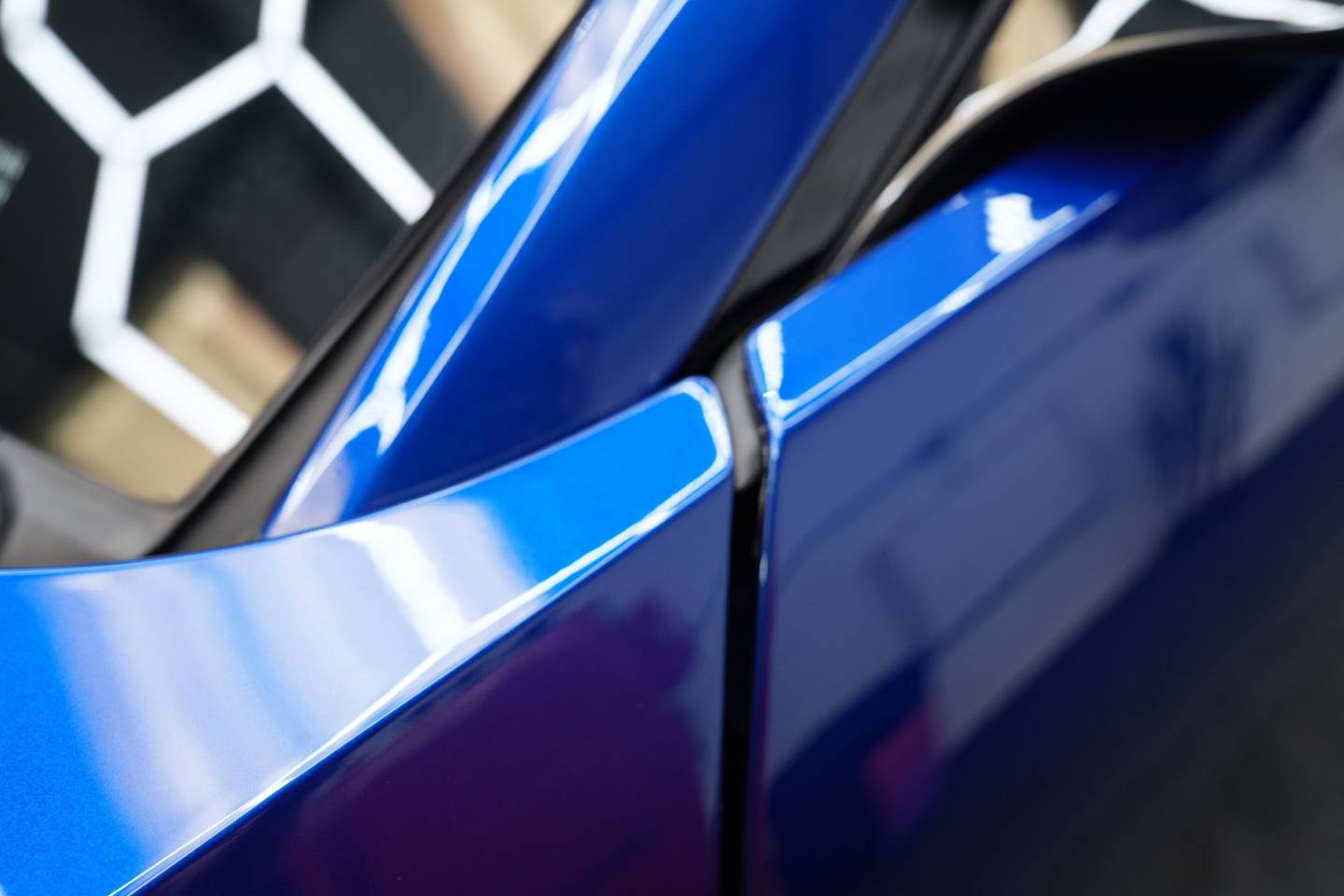 Blue sports car wing mirror and side window