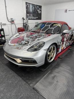 Front three-quarter view of anime-wrapped Porsche convertible