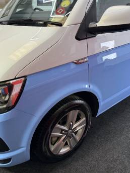 Blue and white VW Transporter front wheel and side panel