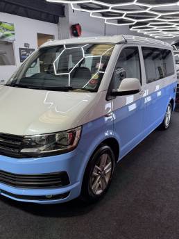 Blue and white VW Transporter Ocean in the workshop
