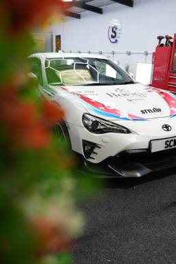 White Toyota GT86 with red and blue anime artwork