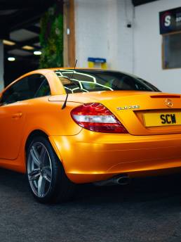 Rear three-quarter view of orange Mercedes-Benz SLK 200