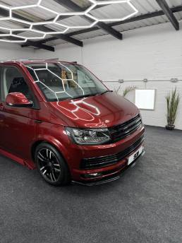 Front three-quarter view of red VW Transporter