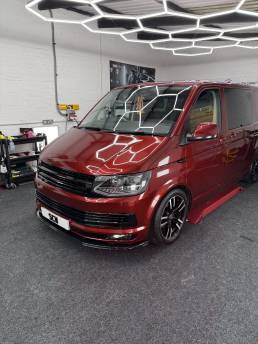 Red VW Transporter with black wheels in the workshop