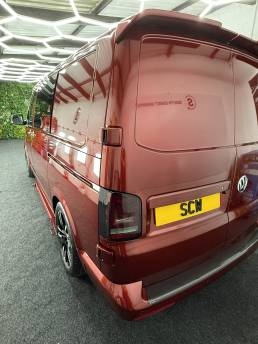 Rear three-quarter view of red VW Transporter