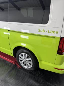Lime green lower side panel on white VW Transporter