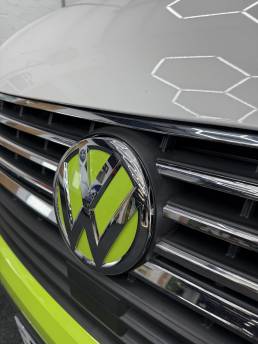 Lime green and white Volkswagen badge on Transporter grille